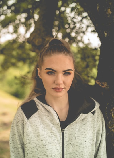 Lady, dressed in a grey zipper hoodie smile
